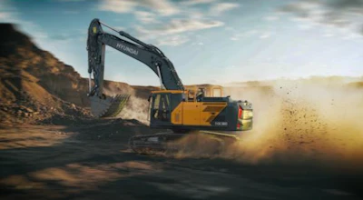 Yellow Hyundai excavator digging and moving earth in dusty construction site with dramatic sky