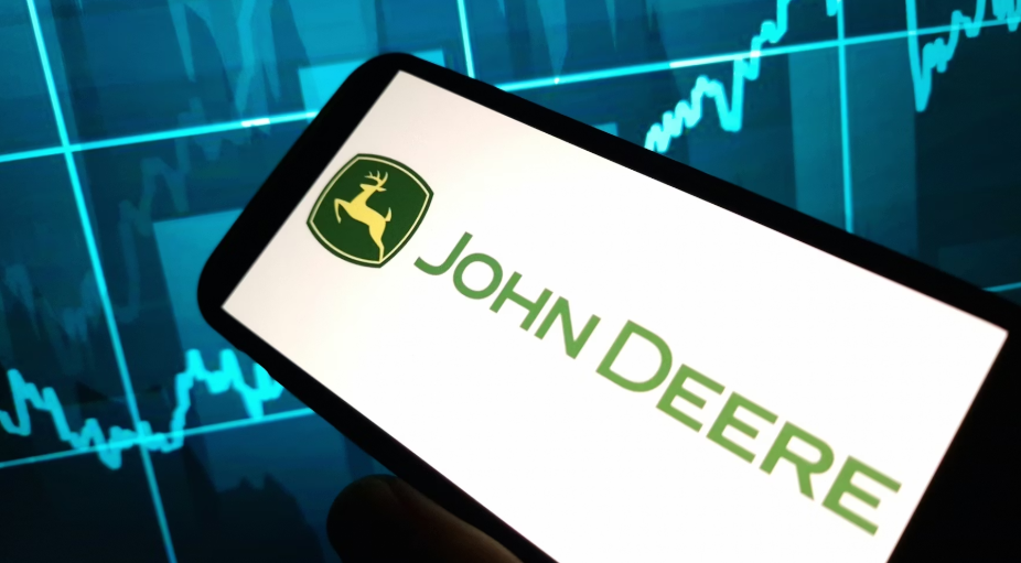 John Deere logo displayed on smartphone with financial market graph backdrop