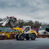 Yellow Liebherr wheel loader moving scrap metal at industrial recycling facility
