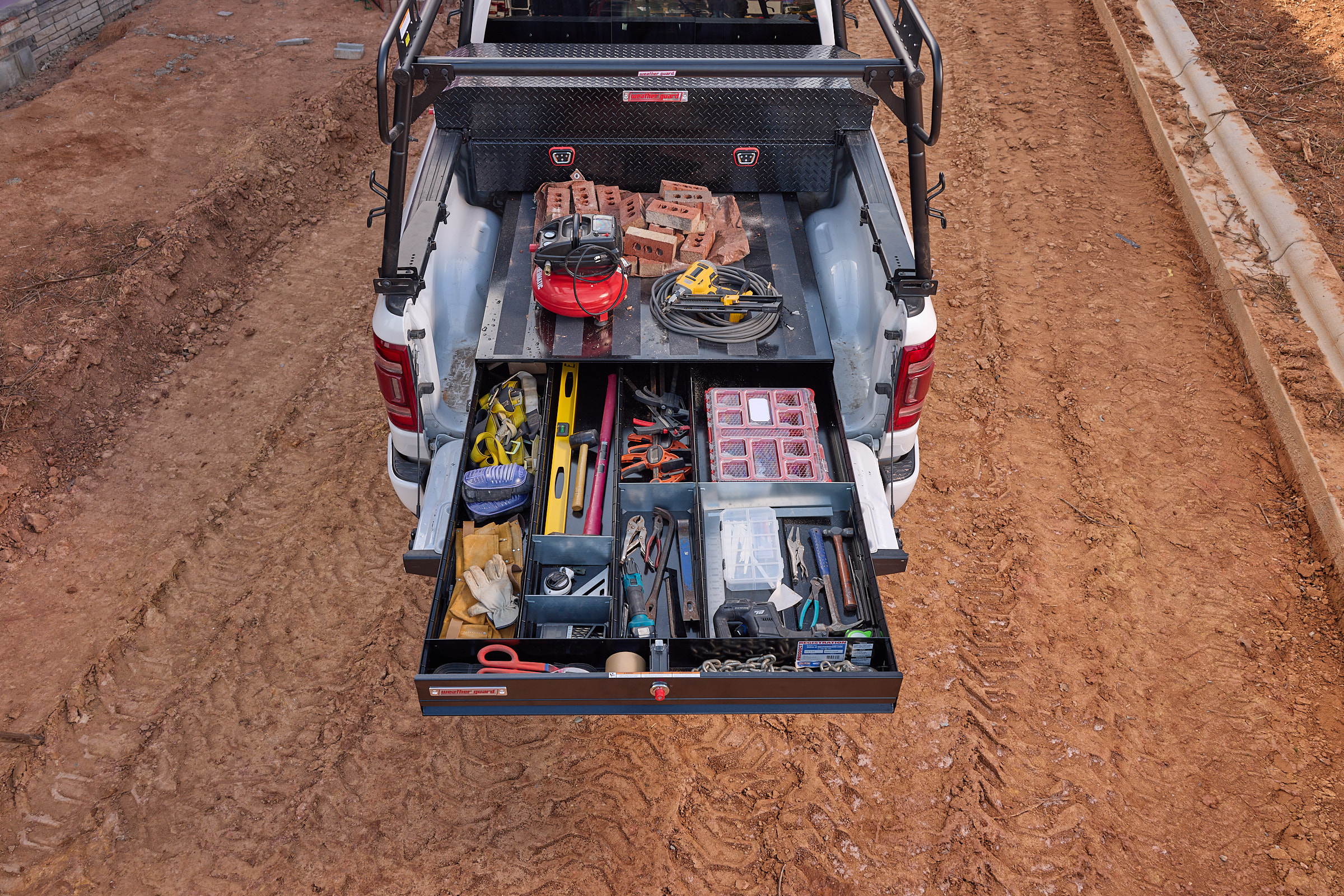 Pickup truck storage drawer with organized tools, work equipment, and supplies