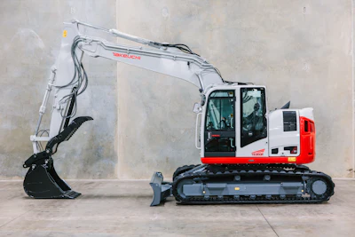 Red and white Takeuchi mini excavator with hydraulic arm and bucket attachment on concrete surface