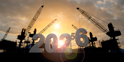 Construction cranes silhouetted against golden sunset with 2026 numbers