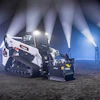 Bobcat skid-steer loader at night with dramatic industrial lighting beams