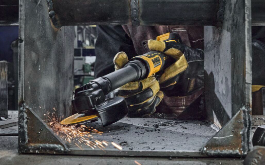 DeWalt angle grinder in use cutting metal with sparks in industrial workshop setting