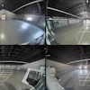 Four-panel security camera feed of industrial warehouse interior with polished concrete floors and metal ceiling structure