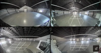 Four-panel security camera feed of industrial warehouse interior with polished concrete floors and metal ceiling structure