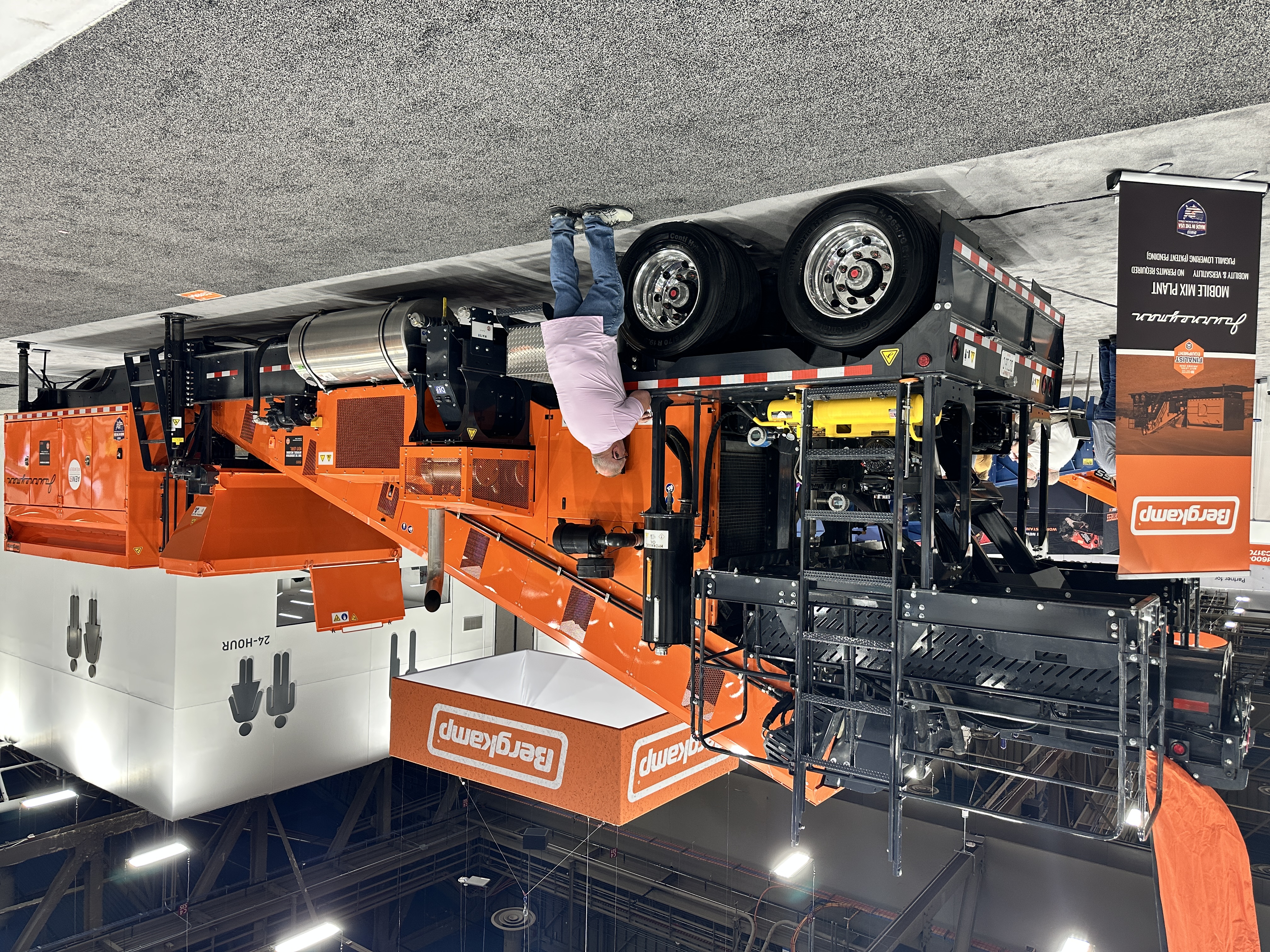 Bergkamp industrial wood chipping equipment displayed at trade show with orange machinery and mobile processing units