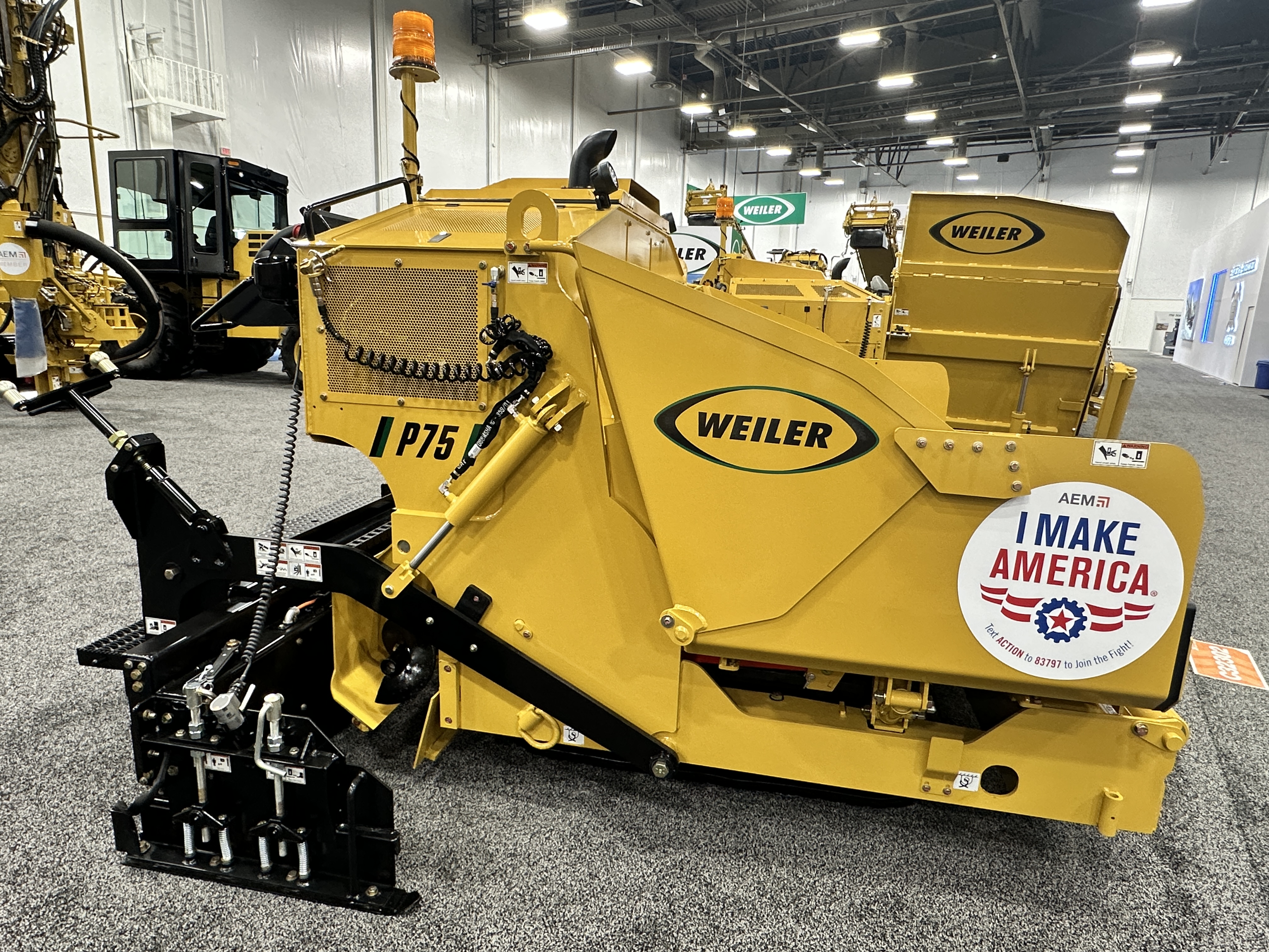 Yellow Weiler industrial wood chipper with black mechanical components displayed at trade show