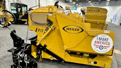 Yellow Weiler industrial wood chipper with black mechanical components displayed at trade show
