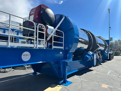 Blue industrial tanker truck with AEM3 branding parked at facility under clear sky