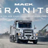 Mack Granite dump truck in industrial quarry setting with mountains and mining equipment in background