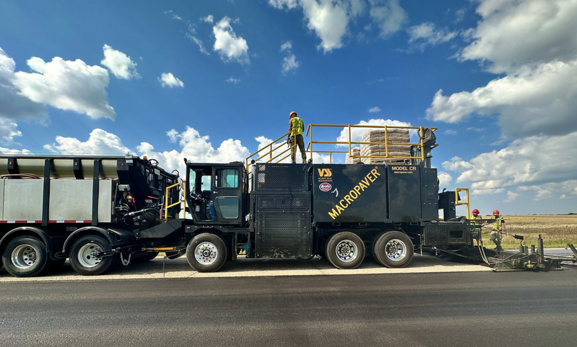 MacPower industrial vacuum truck on highway with clear sky and grassland background