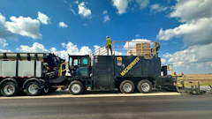 MacPower industrial vacuum truck on highway with clear sky and grassland background