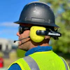 Construction worker wearing black hard hat and neon yellow Sonetics ear protection with microphone headset