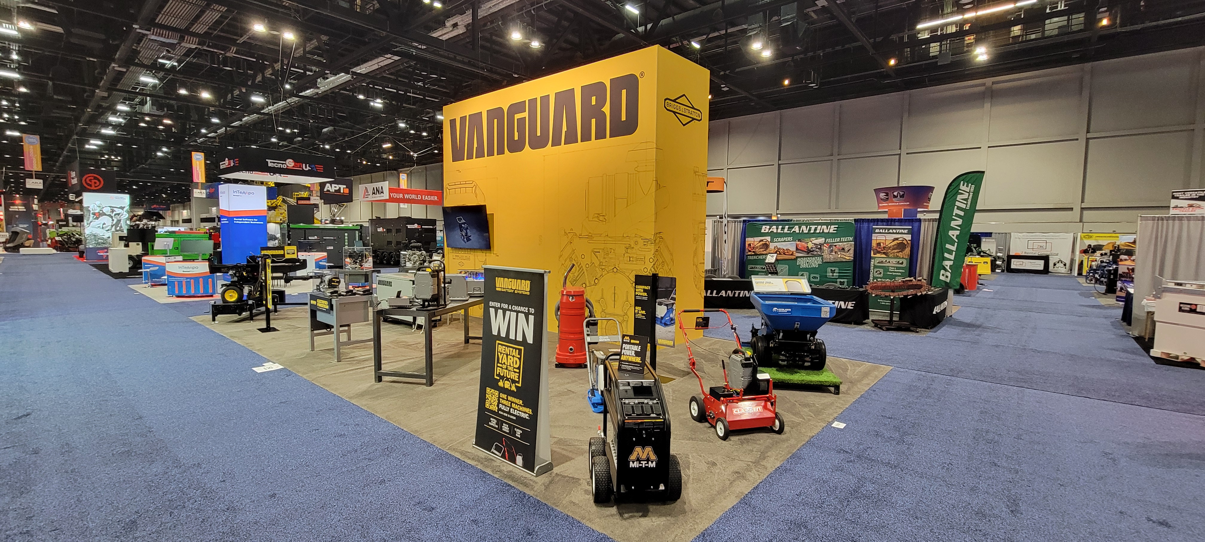Vanguard yellow exhibition booth at a trade show convention center with arcade games and displays