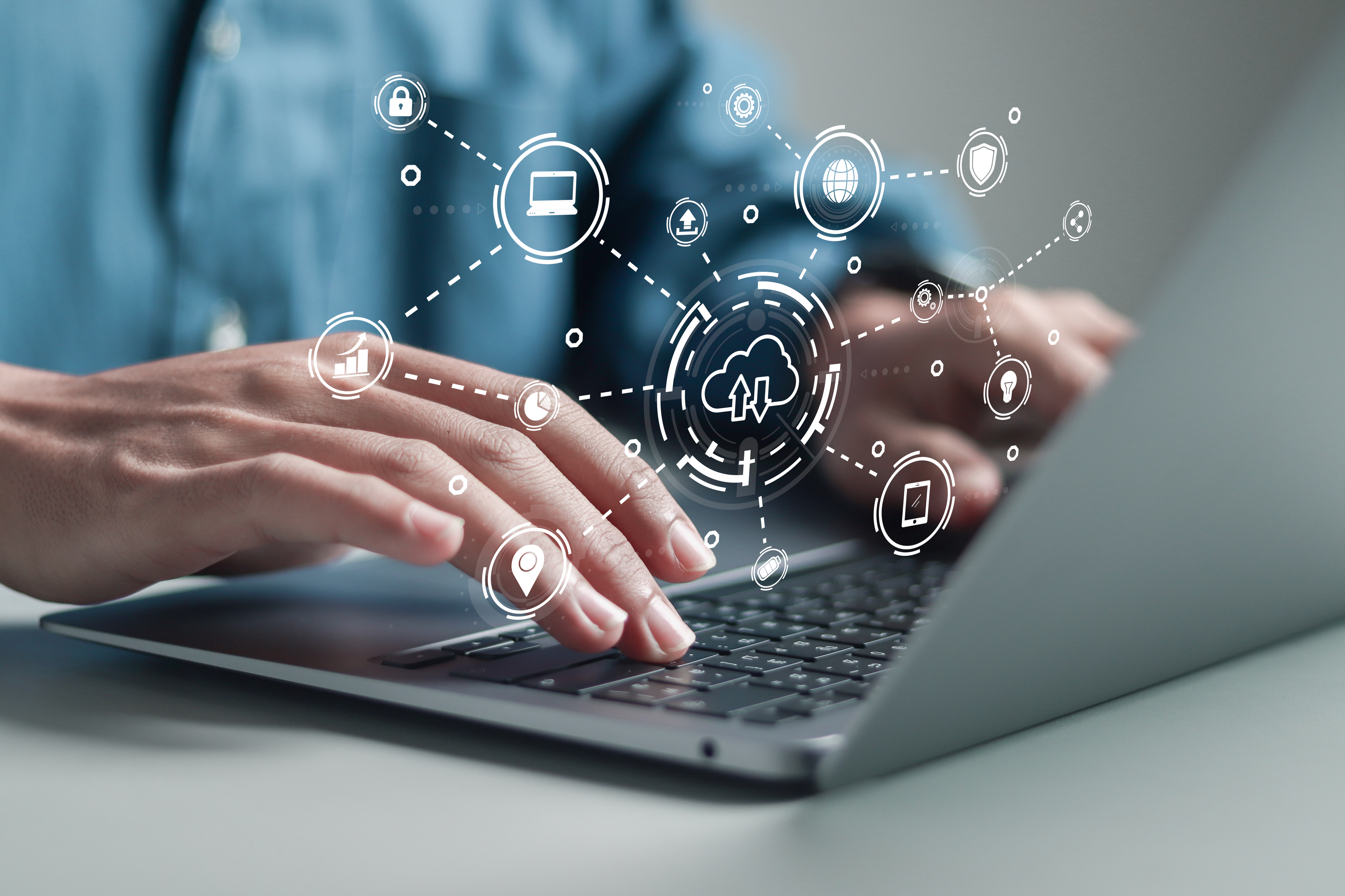 Hands typing on laptop with digital security and cloud computing icons floating above in connected network pattern