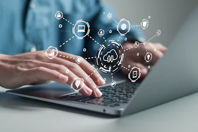Hands typing on laptop with digital security and cloud computing icons floating above in connected network pattern