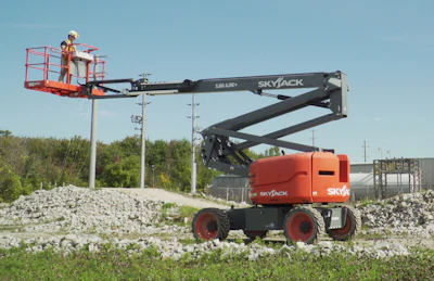 Skyjack articulating boom lift with red platform and black boom extended in outdoor industrial setting
