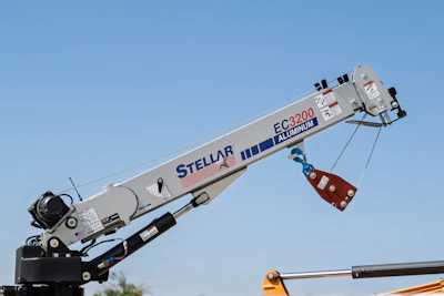 Stellar EC3200 aluminum telescopic boom crane against blue sky with red load basket
