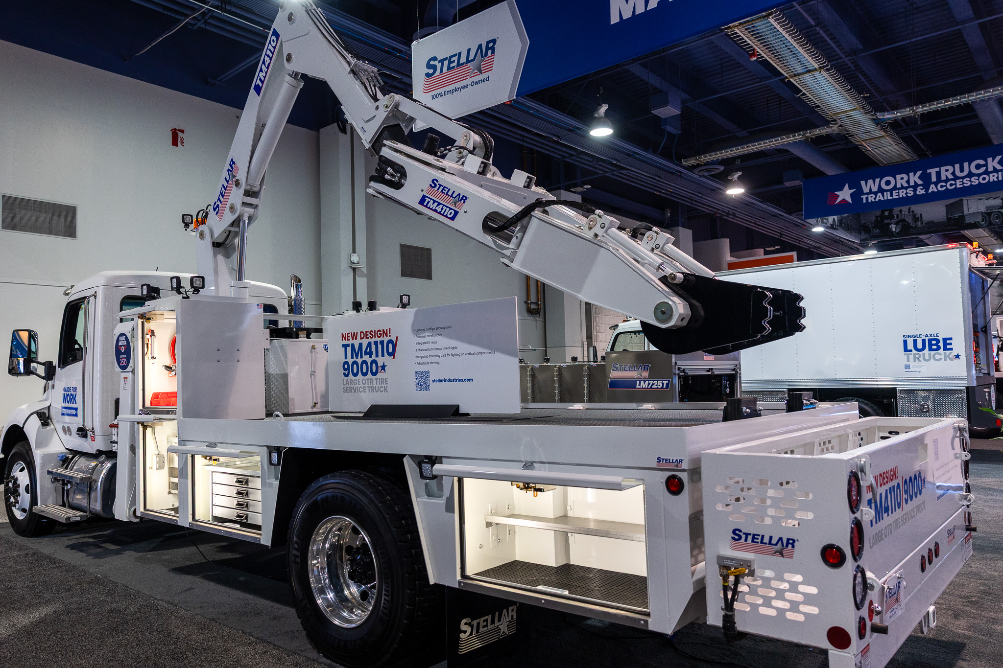 White Stellar lube service truck with hydraulic arm displayed at trade show