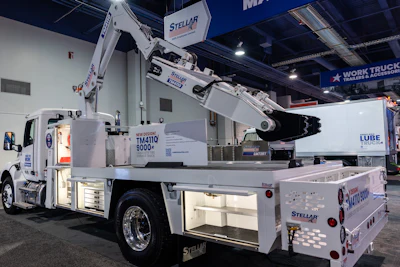 White Stellar lube service truck with hydraulic arm displayed at trade show