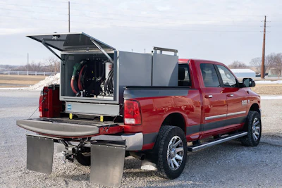 Red pickup truck with open emergency equipment compartment and metal storage boxes mounted on rear
