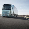 Volvo electric truck driving on highway with white trailer in daylight