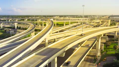 Aerial view of multilevel highway interchange with elevated concrete roadways and light traffic under clear sky