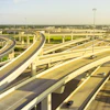 Aerial view of multilevel highway interchange with elevated concrete roadways and light traffic under clear sky