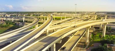 Aerial view of multilevel highway interchange with elevated concrete roadways and light traffic under clear sky