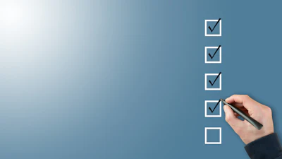 Hand checking off completed tasks on a blue checklist with pen