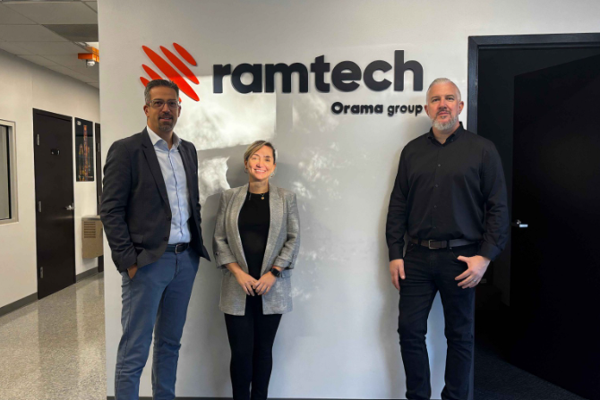 Three business professionals standing in front of Ramtech Orama group office wall signage