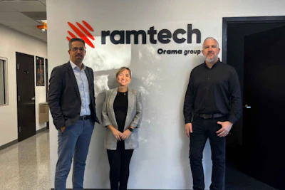 Three business professionals standing in front of Ramtech Orama group office wall signage