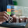 Professional using laptop with holographic project management dashboard displaying colorful timeline charts and task checkmarks