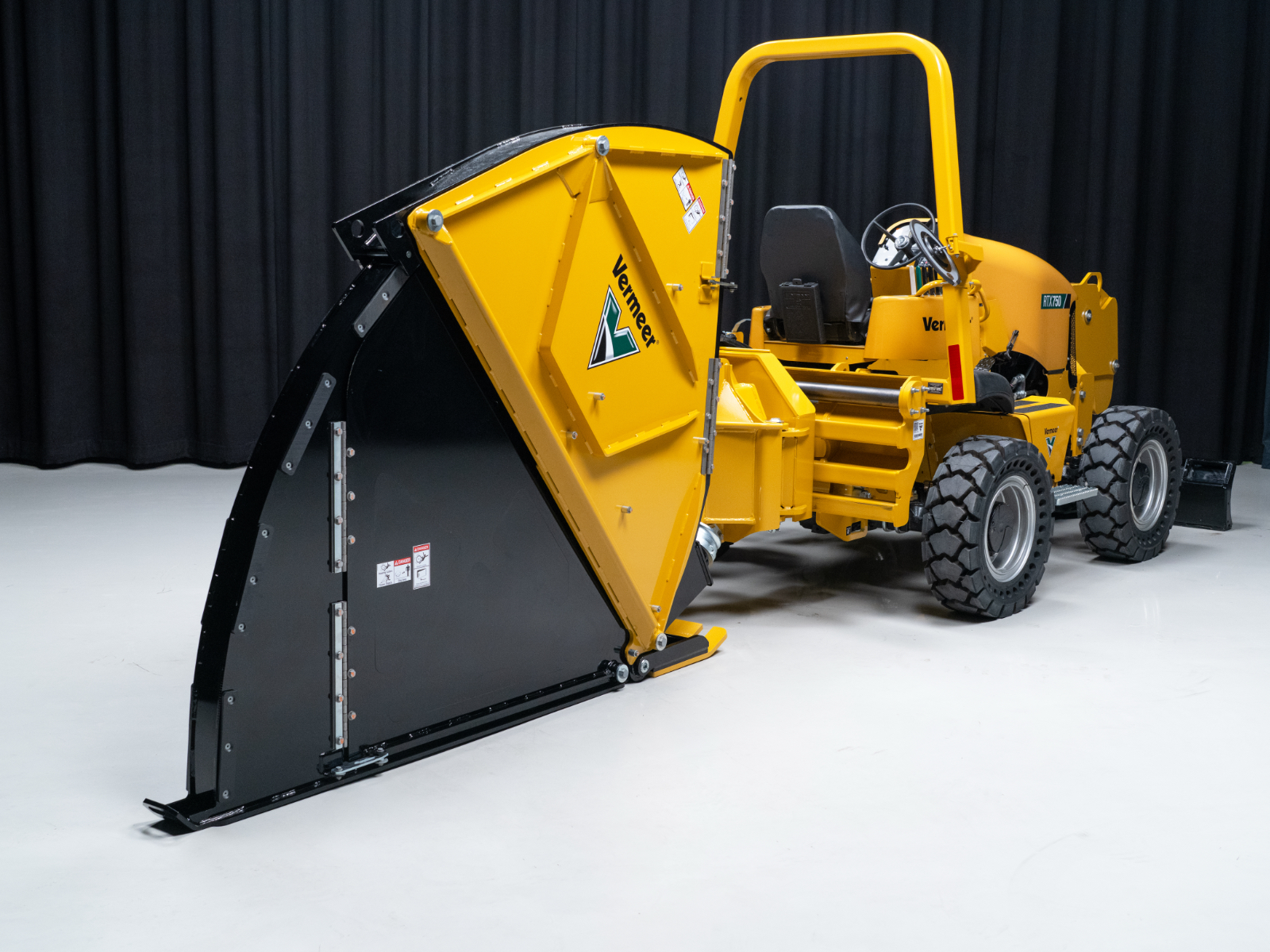 Yellow and black Vermeer wood chipper machine with hopper and collection bin on white background