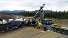 Mobile aggregate processing plant with conveyor systems and heavy equipment in mountainous terrain