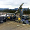 Mobile aggregate processing plant with conveyor systems and heavy equipment in mountainous terrain