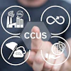 Person touching digital CCUS diagram with four sustainability icons: industrial emissions, circular economy, carbon capture, and green energy