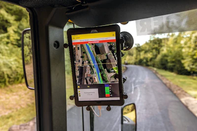 GPS navigation app on tablet mounted in vehicle dashboard showing map with route planning