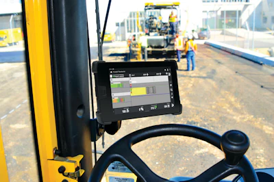 Construction paving equipment with digital display mounted on yellow machinery at active job site