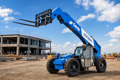 Blue Genie telehandler with extended boom on construction site next to unfinished concrete building