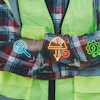 Construction worker in safety vest displaying neon-glowing icons representing inspection, tools, and energy efficiency
