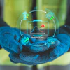 Worker in safety gear holding holographic interface displaying predictive analytics and alert monitoring system