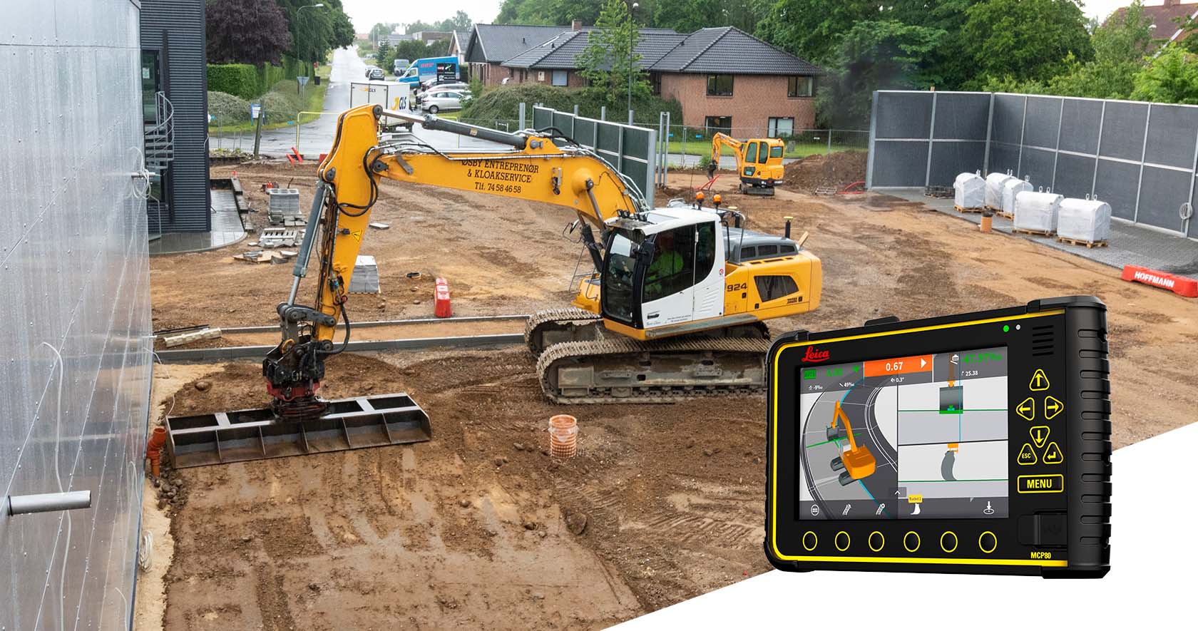 Construction excavator with tablet displaying equipment controls on active job site