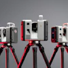 Three Leica laser scanning devices mounted on red tripods against gray background