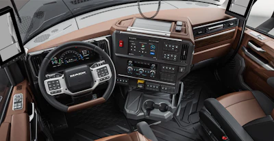 Mack Trucks commercial vehicle interior cabin with brown leather seats, black steering wheel, and digital dashboard display