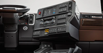 Truck dashboard interior showing steering wheel, instrument cluster, climate controls, and wood-trimmed trim panels