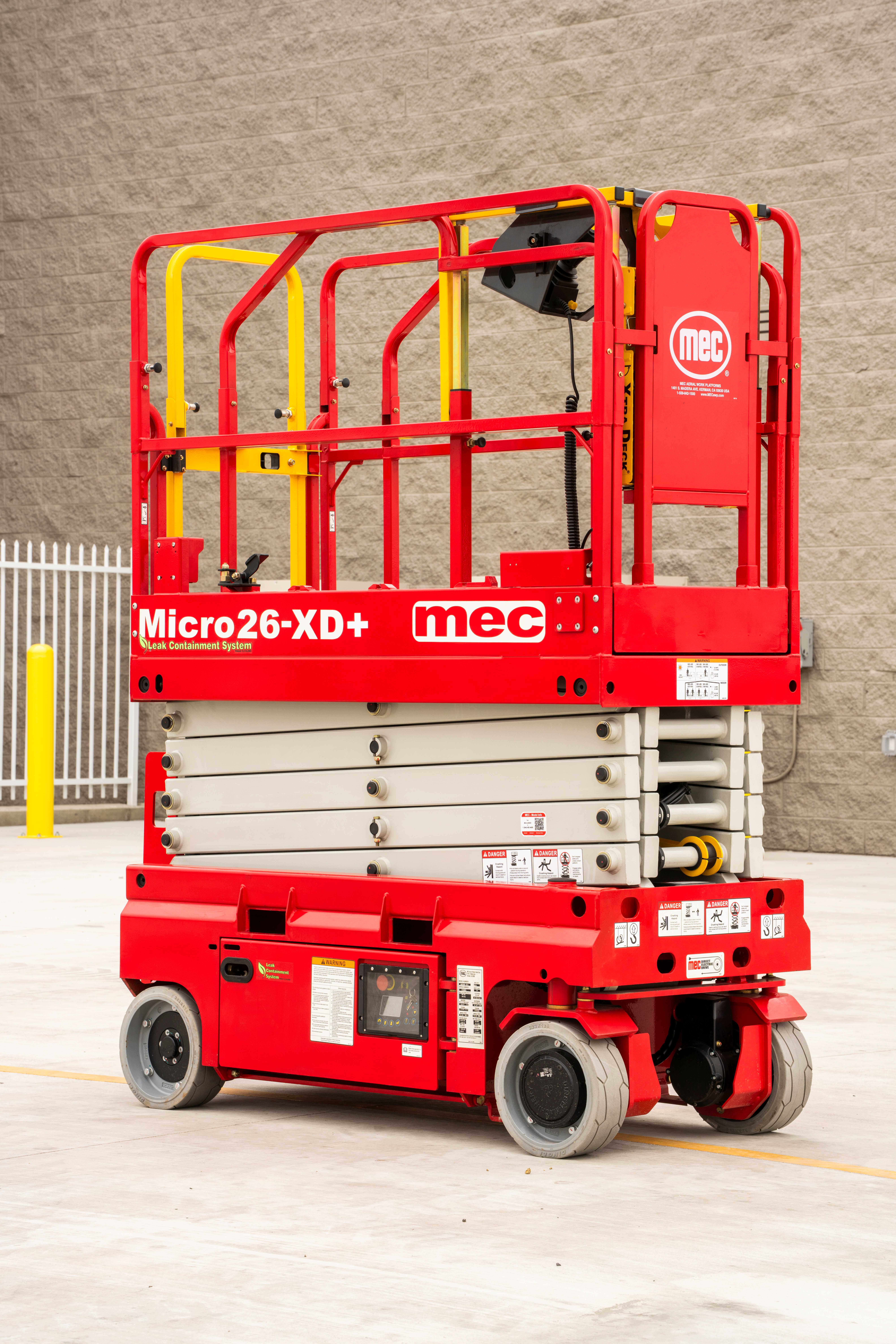 Red and yellow MEC Micro26-XD+ scissor lift platform with safety cage and hydraulic base on concrete floor