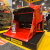 Red concrete mixer truck on display at industrial equipment exhibition with yellow Allu branding