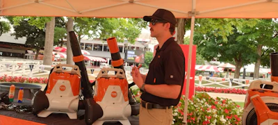 Segway product demonstration at outdoor event with orange personal mobility devices under tent canopy